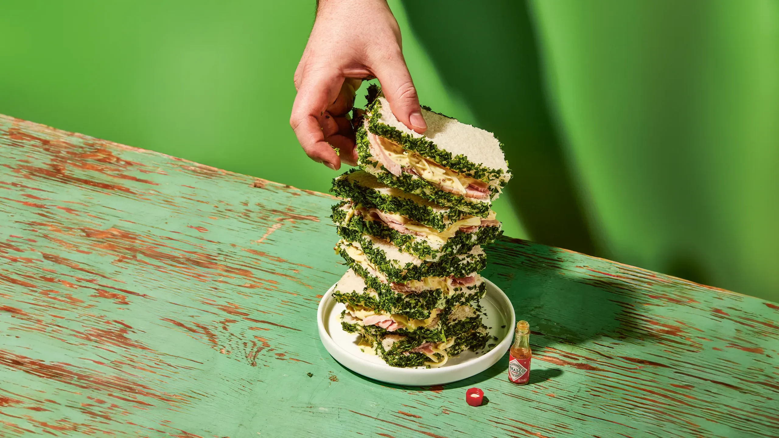 Image of a hand grabbing the ham and celery sandwich