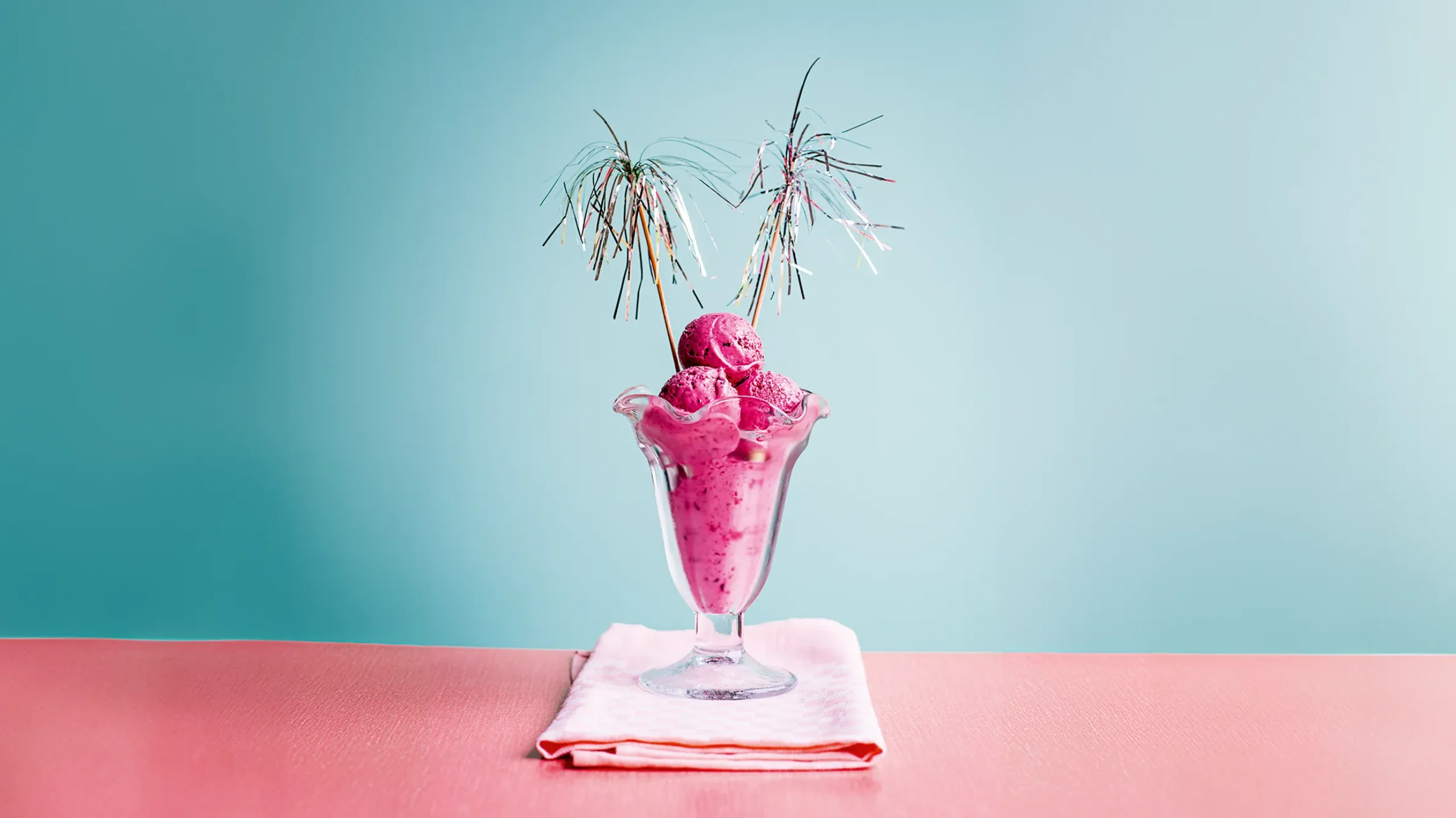 An image of a pink berry ice cream on a light blue background
