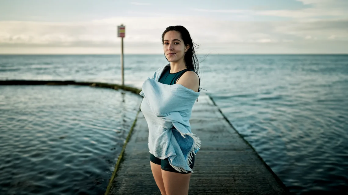 image of Freya with a towel wrapped around her in front of a sea swimming pool