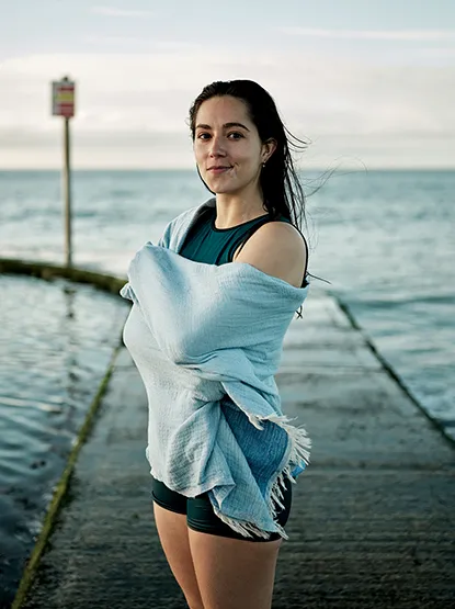 image of Freya with a towel wrapped around her in front of a sea swimming pool