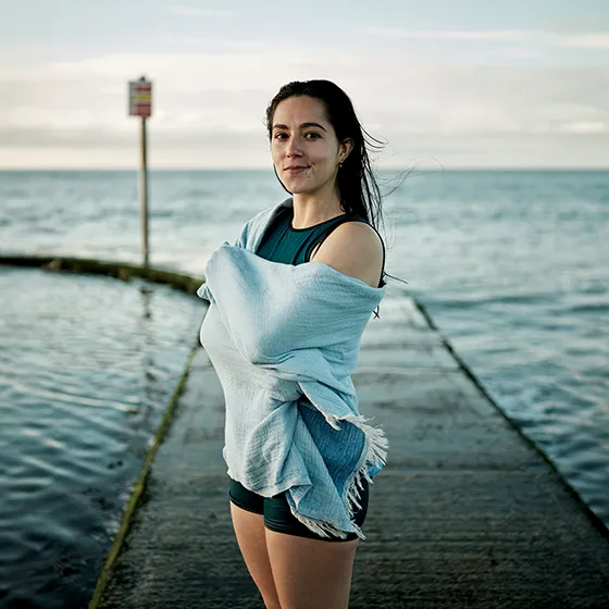 image of Freya with a towel wrapped around her in front of a sea swimming pool
