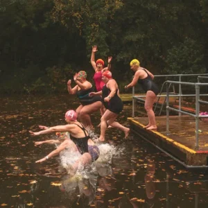 A group of ladies jumping into a pond