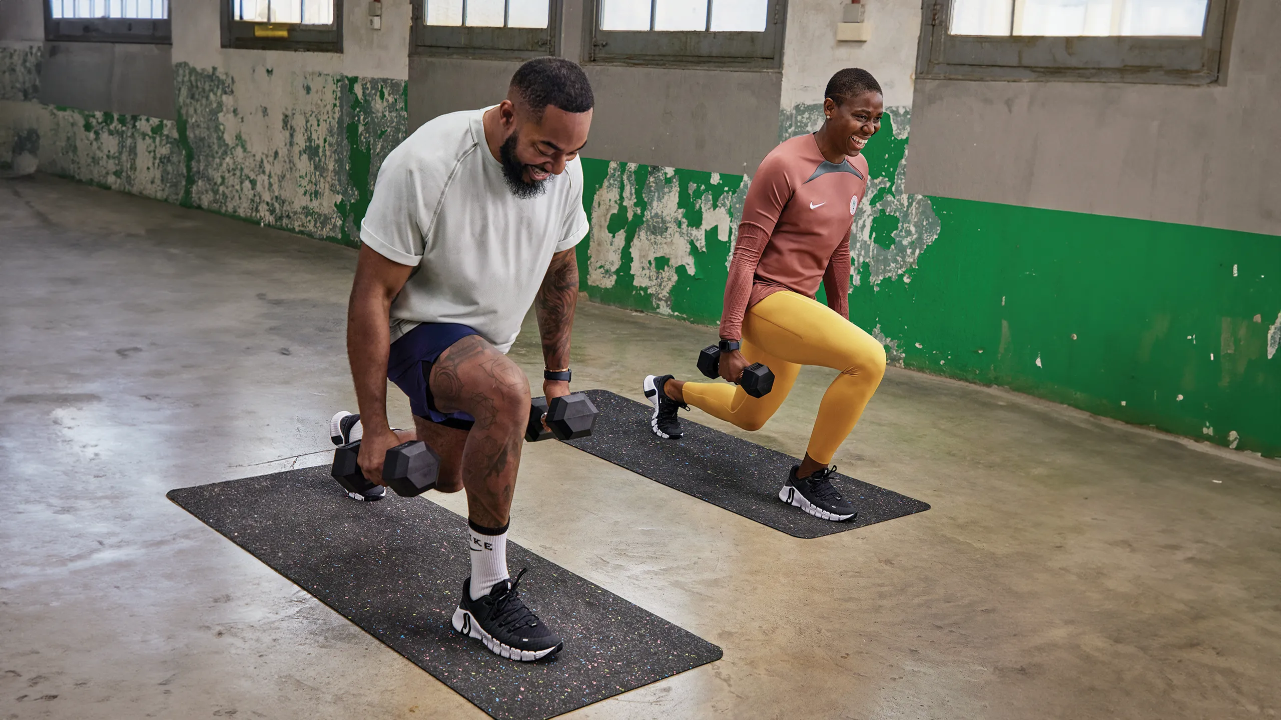 Image of a man and a women in a gym doing a lunge