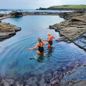 Two women getting in to a tidal pool 