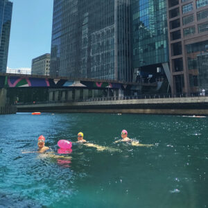 a group of people swimming surrounded by skyscrapers