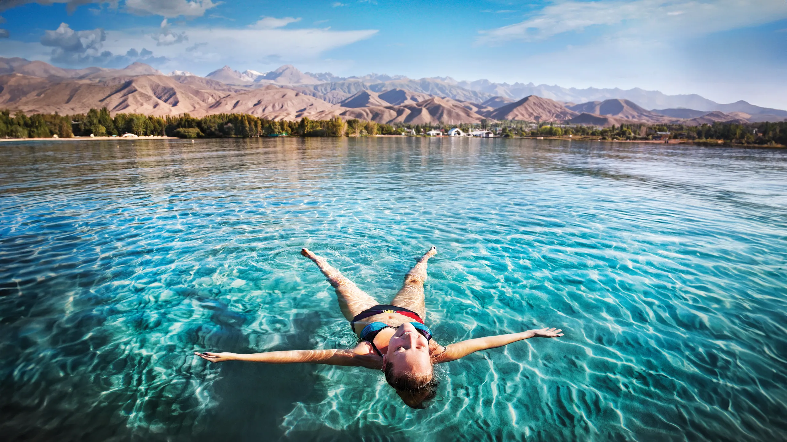Woman floating in a Kyrgyzstan lake