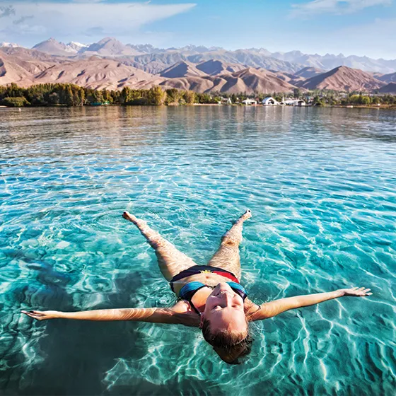 Woman floating in a Kyrgyzstan lake