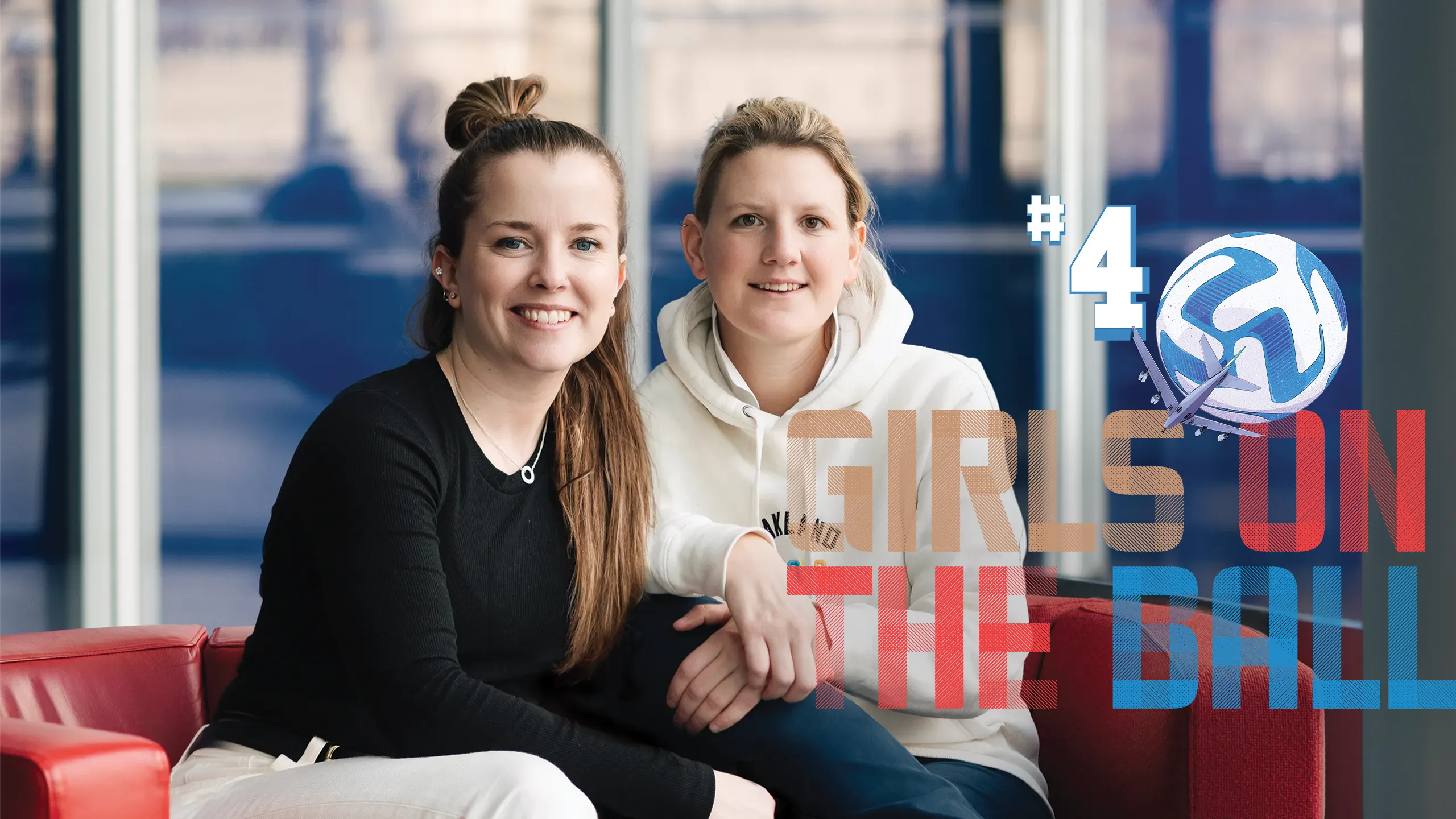 Two women from Girls on the ball on a red sofa with windows behind