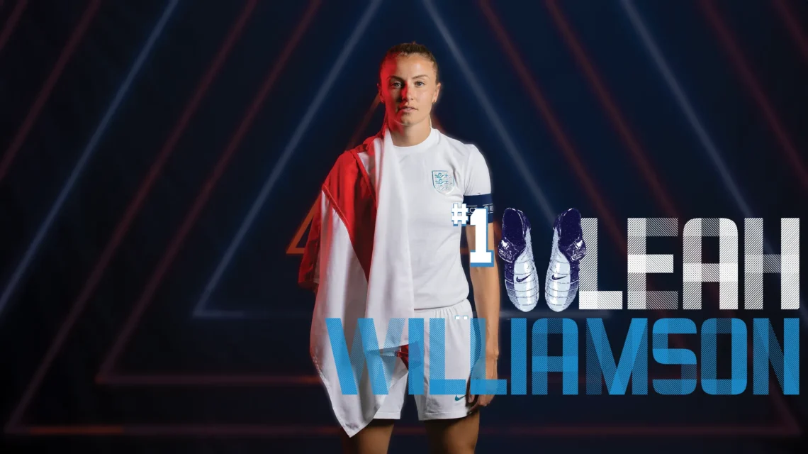 Picture of Leah Williamson wearing her England football kit with a England flag draped over her right shoulder