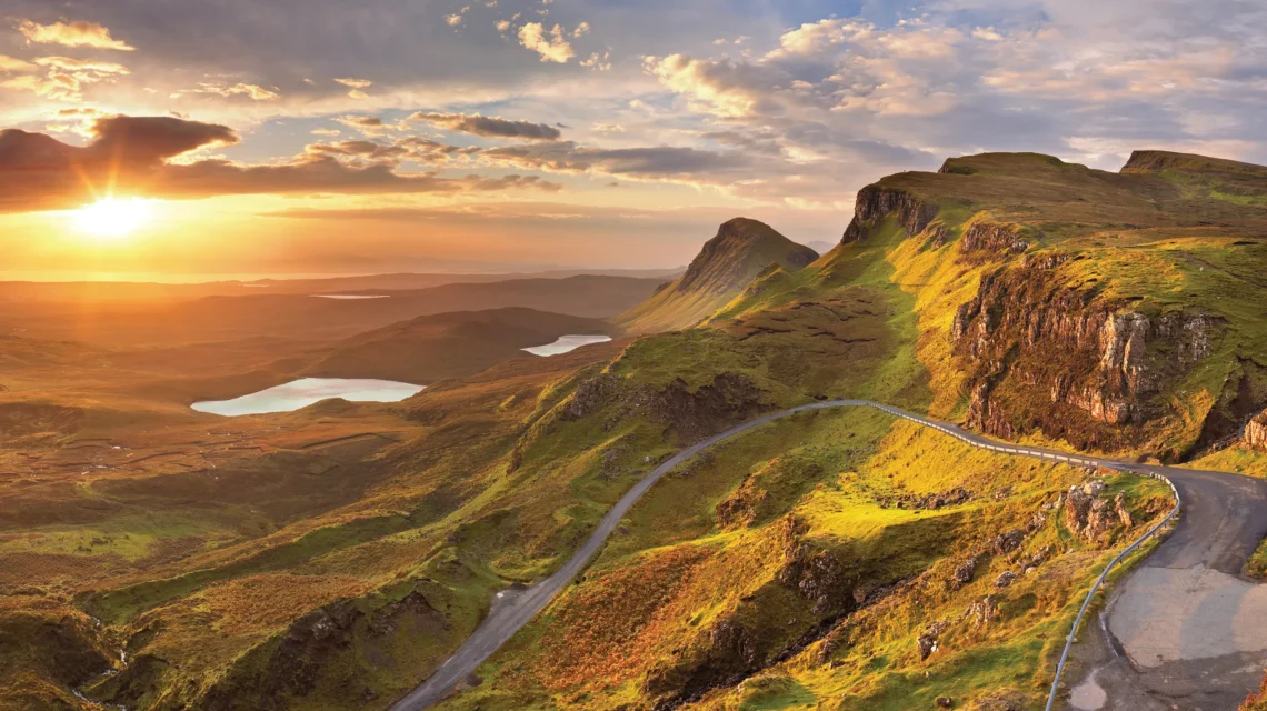 Scenic image of a road leading through the hills and a lake in the distance