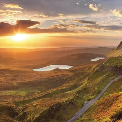 Scenic image of a road leading through the hills and a lake in the distance