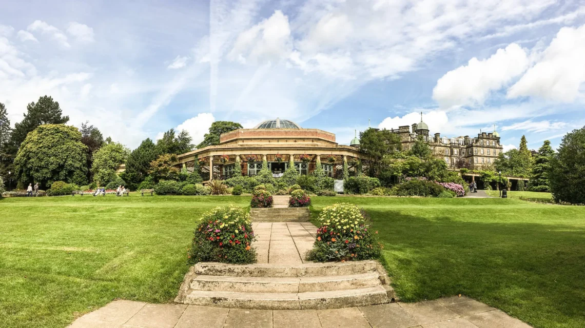 Stone steps and a paved path lead through a manicured lawn toward the Sun Pavilion in Harrogate's Valley Gardens.