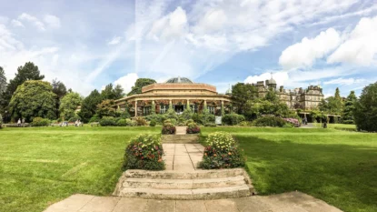 Stone steps and a paved path lead through a manicured lawn toward the Sun Pavilion in Harrogate's Valley Gardens.